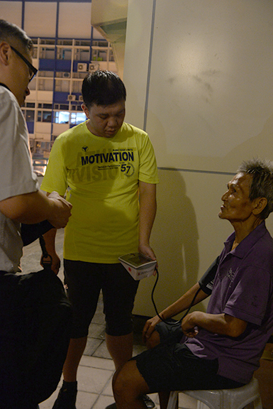 Yu takes blood pressure for a street sleeper.