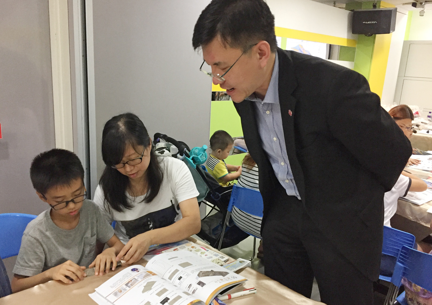 Mr Wilfred Leung, Development Director of The Salvation Army (right) shares paper airplanes origami skills with participants.